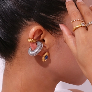 Macro detail of 18K gold plated hammered earrings and gemstone rings for women