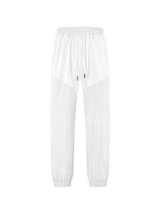 Detail of white casual trousers featuring drawstring waistband and textured fabric panels