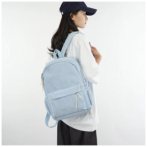 Side view of light blue corduroy backpack on model showing texture and large capacity