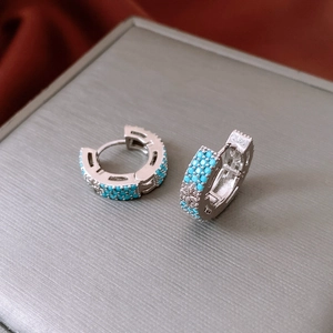 Gros plan de boucles d'oreilles vintage en argent avec perles turquoise et motifs floraux