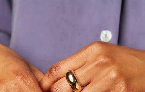 Gros plan d'une bague en acier titane doré poli avec une surface bombée lisse au doigt