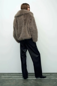 Brown faux fur jacket with knot buckle details shown from a stylish back view on model