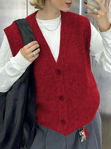Gilet in maglia rossa da donna con scollo a V e bottoni sopra una maglia bianca