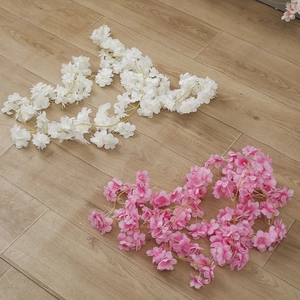 Artificial cherry blossom vines in pink and white on a natural wooden background