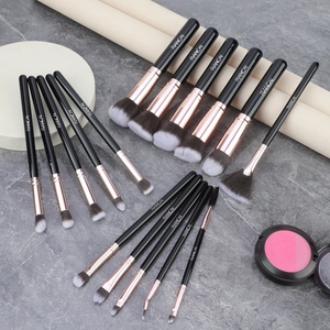 Close-up of 16 professional makeup brushes with rose gold ferrules and black handles
