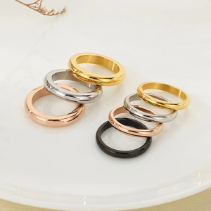 Close-up of colorful polished stainless steel rings stacked on a ceramic plate