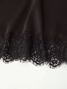 Detail aus schwarzem Seidensatin mit elegantem Wimpernspitzen-Saum und feinen Nähten