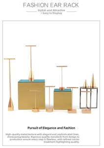 Macro detail of T-shaped jewelry stands and conical ring holders in matte champagne gold finish