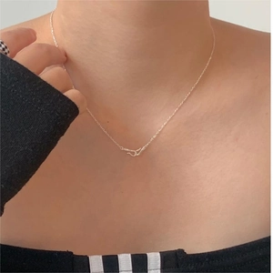 Macro shot of minimalist 925 sterling silver wavy curve pendant on a delicate O-chain