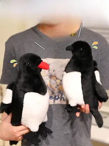 Realistic magpie plush dolls in black and white shown held by hands for size scale