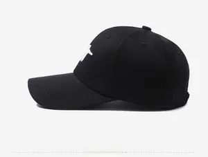 Close-up of black cotton baseball cap featuring detailed white letter embroidery on the side