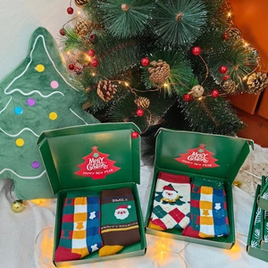 Detail of Christmas gift box with festive Santa and snowflake pattern cotton socks