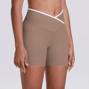 Detail of high-waisted yoga shorts with crossover V-waist and white contrast piping