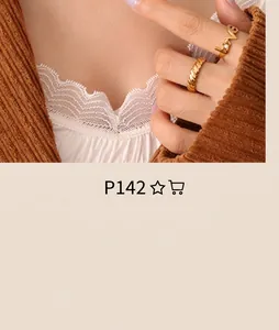 Close-up of a gold LOVE letter ring and a twisted band ring worn on fingers