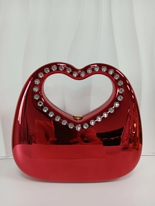 Glossy red heart-shaped evening bag with rhinestone handle and stone pattern