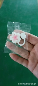 Close-up of white cherry blossom silicone straw topper in protective clear packaging