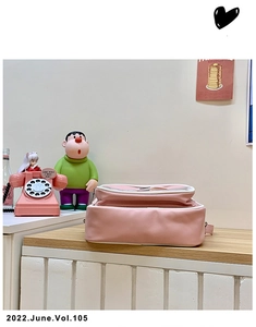 Vue détaillée du fond du sac en similicuir rose avec coutures nettes et crochets en métal