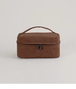 Detailed view of the brown suede makeup bag showing dual metal zippers and texture