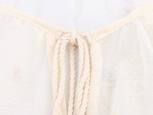 Vue détaillée de l'encolure de blouse brodée avec fermeture à cordon tissé