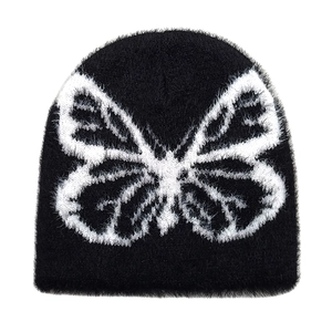 Close-up of black fuzzy knit beanie featuring white butterfly jacquard pattern
