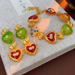Vintage heart jewelry set with colorful enamel flowers and pearls on golden base