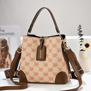 Retro patterned bucket bag with brown leather trim and two interchangeable straps