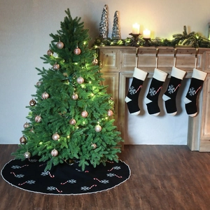Knitted Christmas tree skirt with snowflakes and candy cane patterns in home setting