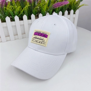 Detail shot of a white cotton baseball cap featuring a yellow boarding pass fabric patch