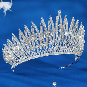 Sparkling silver tiara with rhinestones and hollow pointed design on navy blue background
