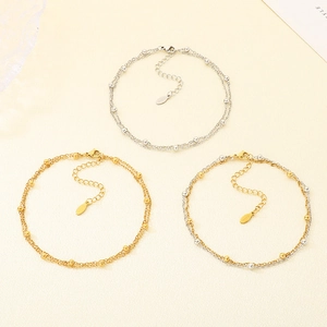 Detailed close-up of double-layered beaded bracelets in gold and silver finishes
