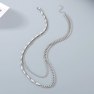 Close-up of layered silver curb chain and elongated link splicing necklace design