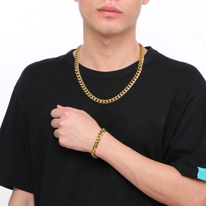 Men's gold Cuban link chain necklace and bracelet set shown on a male model