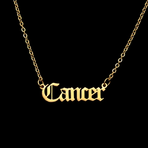 Detailed close-up of golden Gothic Cancer constellation letter pendant with O-chain