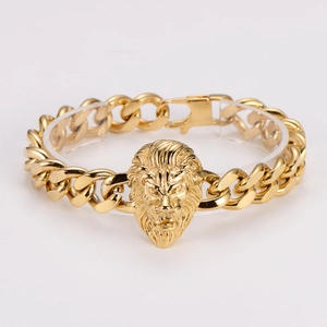 Close-up of golden lion head emblem on a thick stainless steel Cuban link bracelet
