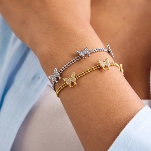 18K gold and silver butterfly charm bracelets with zircon beads on model wrist