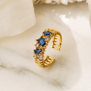 Macro shot of gold 18K plated adjustable ring with blue zircon and white crystal accents