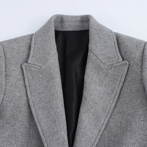 Close-up of light gray wool coat featuring notched lapels and textured fabric detail