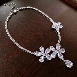 Detail view of flower necklace with sparkling zircon droplets and silver base for weddings