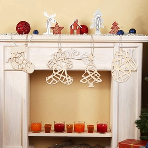 Hanging wooden Christmas ornaments with geometric hollow designs on a white fireplace