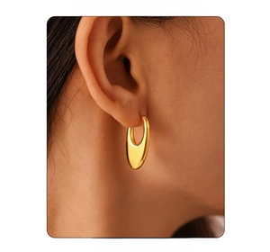 Close-up of minimalist U-shape gold earrings on a model showing polished texture