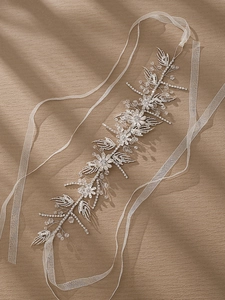 Macro detail of silver floral hairband with white rhinestones and crystal beads