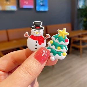 Macro detail of snowman and Christmas tree PVC charms for holiday accessory sets