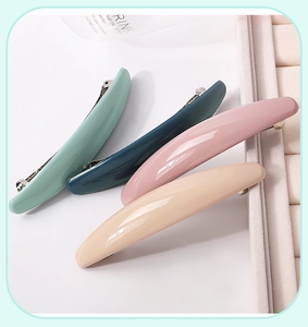Close-up of four colorful resin hair clips in pastel green, blue, pink and beige