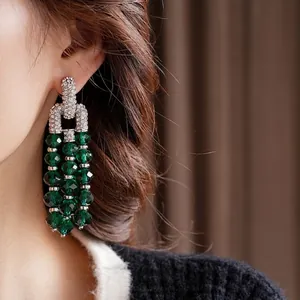 Vintage silver tassel earrings with emerald green crystals and sparkling diamonds on woman