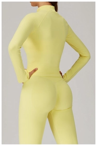 Detailed texture of yellow seamless high-stretch fabric on a slim fit athletic yoga jacket