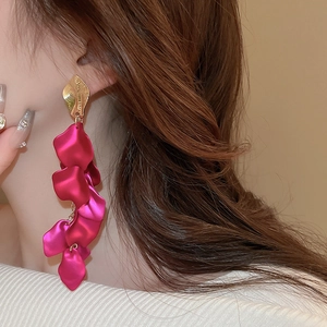 Close-up of rose red flower petal tassel earrings with textured gold leaf studs