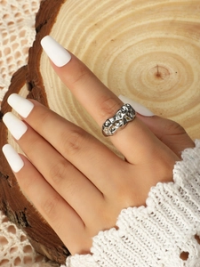 Macro view of textured silver lava ring on model with natural wooden background
