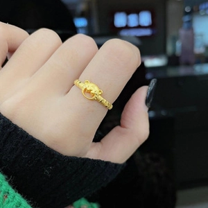 Close-up of a gold bear ring worn on index finger with elegant polished finish