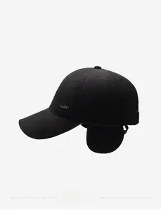 Detail view of winter baseball cap with earflaps and silver metal Fashion label