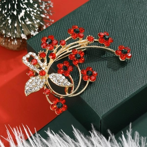 Elegant Christmas flower brooch with red rhinestones on festive gift box background